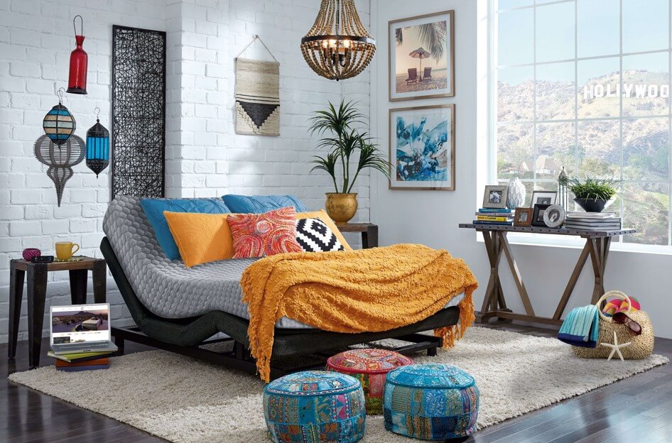 Quarto com decoração colorida de estilo boho, destacando uma cama articulada com o colchão inclinado na cabeceira e nos pés. Uma opção de colchão para terceira idade que oferece conforto ajustável e design moderno.