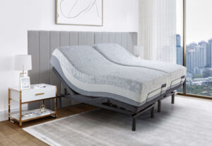 Cama de casal articulada em um quarto moderno e clean com vista para a cidade. As duas metades da cama estão elevadas em posições diferentes, ideal para um colchão para terceira idade que personaliza o suporte e a inclinação de cada lado.
